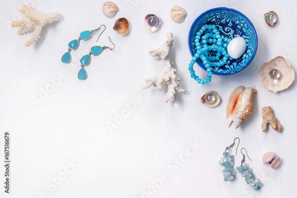 Fototapeta the white background on the marine theme with seashells, beads, corals and earrings