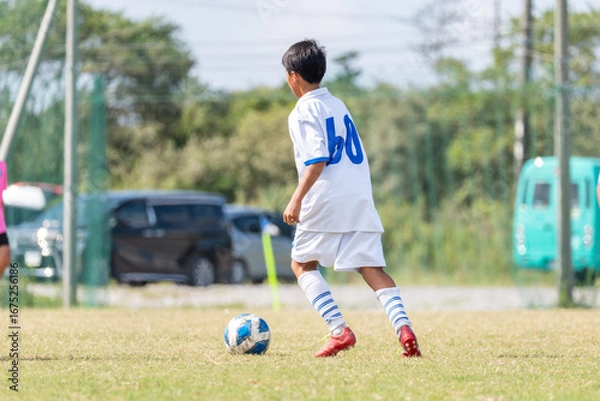 Fototapeta サッカーの試合をする中学生の男の子