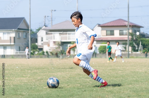 Fototapeta サッカーの試合をする中学生の男の子