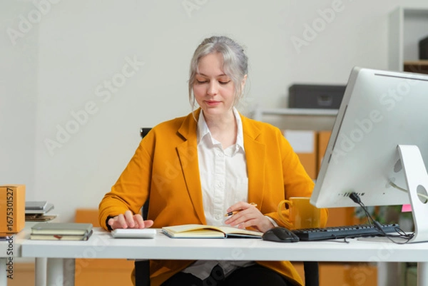 Fototapeta woman using calculator in her hand, calculating financial expense at home office, online market packing box delivery,Startup successful small business owner, SME, concept.