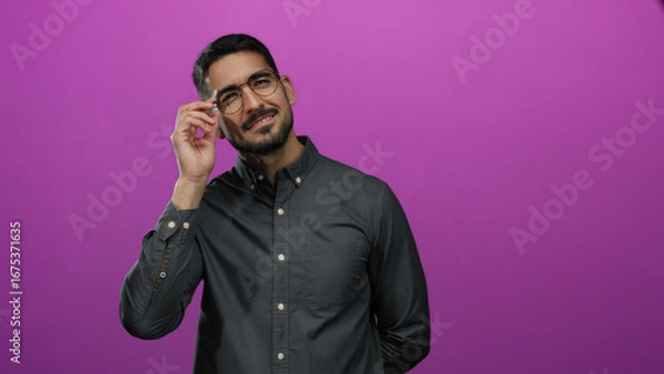 Obraz Man smiling confidently against a vibrant pink background in a portrait with glasses and dark hair wearing a casual shirt creating a stylish and modern composition