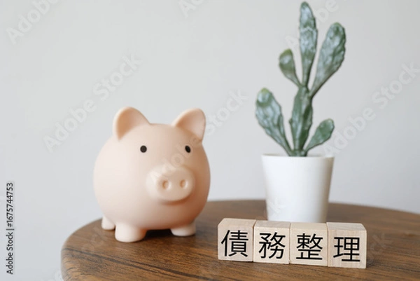 Fototapeta 債務整理と貯金のイメージ、ブタの貯金箱と観葉植物。