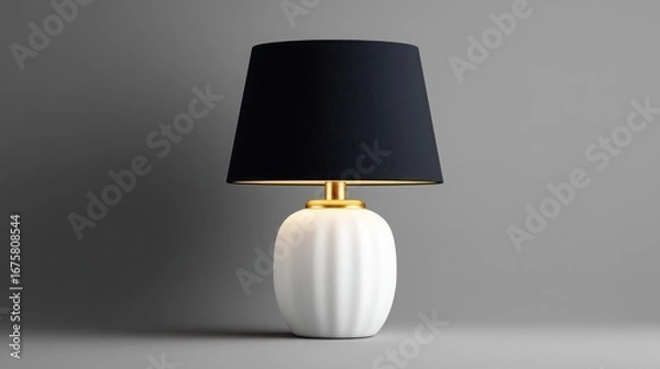 Fototapeta Elegant Luminescence: A sophisticated bedside lamp with a pristine white ceramic base and a sleek black shade, emanating a soft, inviting glow on a solid grey background.