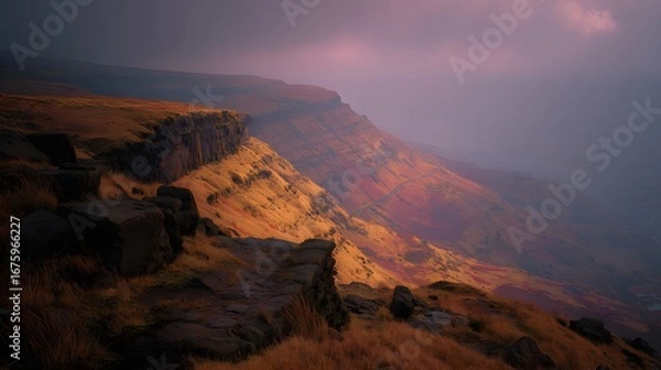 Fototapeta A dramatic mountain vista bathed in the warm hues of a late afternoon light, showcasing a steep cliff face and the surrounding landscape.