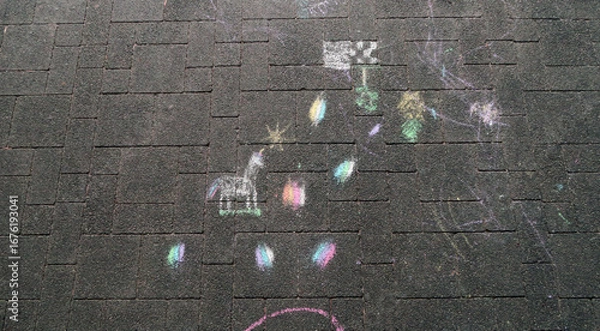 Fototapeta Colorful chalk drawings on a paved surface, including a unicorn and scattered, vibrant shapes and doodles.