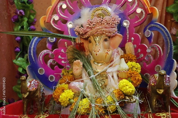 Fototapeta Ganapati festival celebration at home with a beautifully decorated Ganesh idol, flowers, lights, and traditional offerings, symbolizing devotion, prosperity, and cultural heritage in a festive atmosph