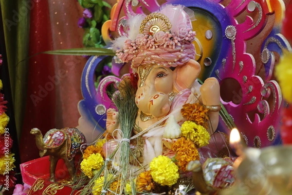 Fototapeta Ganapati festival celebration at home with a beautifully decorated Ganesh idol, flowers, lights, and traditional offerings, symbolizing devotion, prosperity, and cultural heritage in a festive atmosph