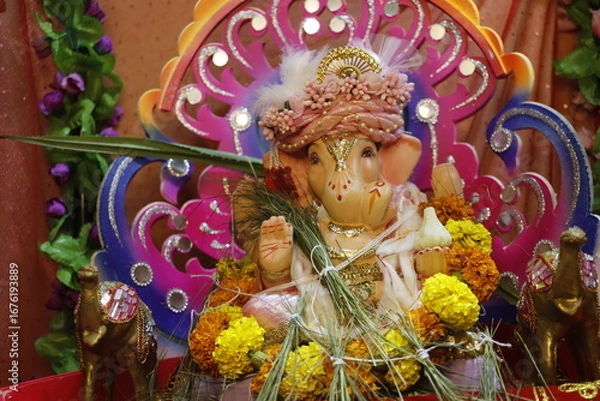 Fototapeta Ganapati festival celebration at home with a beautifully decorated Ganesh idol, flowers, lights, and traditional offerings, symbolizing devotion, prosperity, and cultural heritage in a festive atmosph