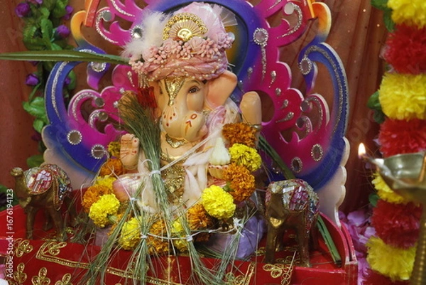 Fototapeta Ganapati festival celebration at home with a beautifully decorated Ganesh idol, flowers, lights, and traditional offerings, symbolizing devotion, prosperity, and cultural heritage in a festive atmosph