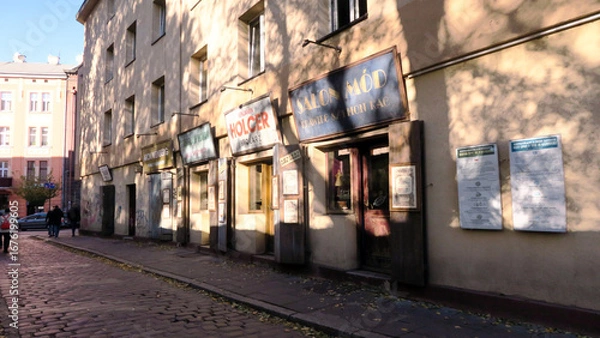 Fototapeta Kraków, Poland. Szeroka street, is disguised to look like a row of early 20th century trade shops and is decorated with relating to the area's Jewish heritage, in Kazimierz.