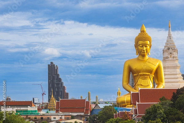 Fototapeta A large seated Buddha or Buddha Dhammakaya Dhepmongkol at Paknam Phasi Charoen temple on a blue sky day.