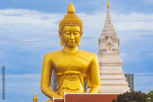 Fototapeta A large seated Buddha or Buddha Dhammakaya Dhepmongkol at Paknam Phasi Charoen temple on a blue sky day.