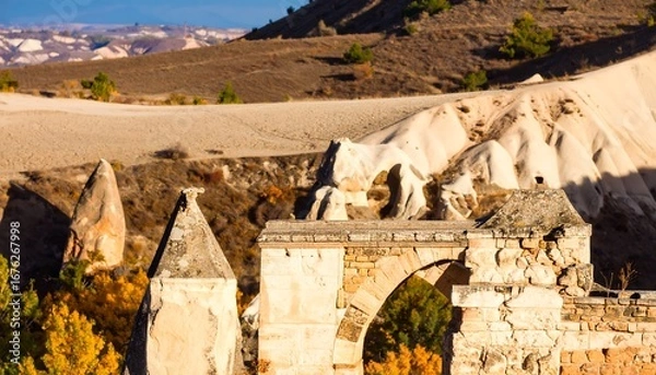 Fototapeta Ancient stone archway, valleys, and hills