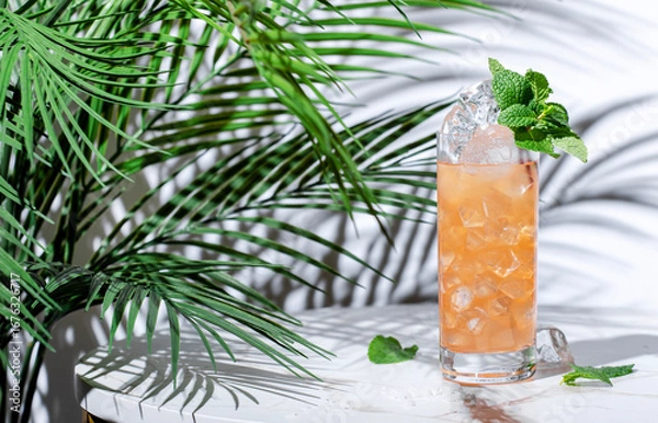 Fototapeta Salty ginger-ade alcohol free cocktail drink with lemon juice, dates, salt, cumin, ginger beer and mint