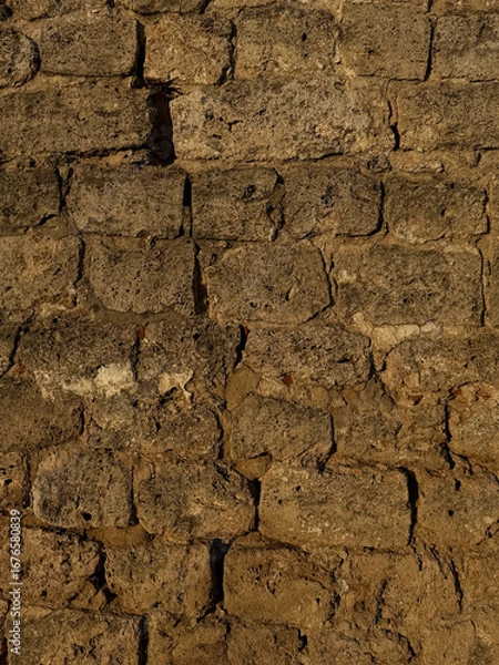 Fototapeta Close-up of historic stone wall texture from Nizhny Novgorod Kremlin. Historic building materials concept. Handheld mobile photo, selective focus, sunlight, non AI