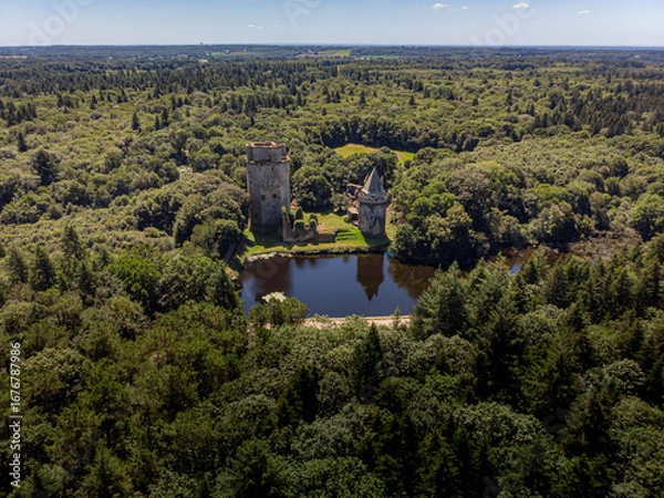 Fototapeta Aerial photograph of Château de Largoët in Brittany, France, surrounded by dense forest. The image emphasizes the medieval fortress’s defensive architecture, and stone towers.