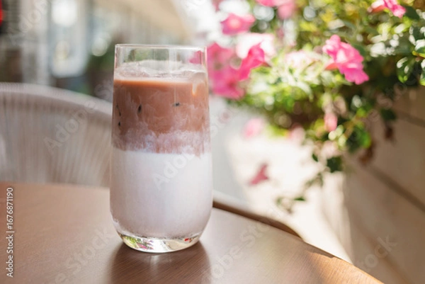 Fototapeta Close-up of an iced mocha coffee on a table at a street cafe in summer.