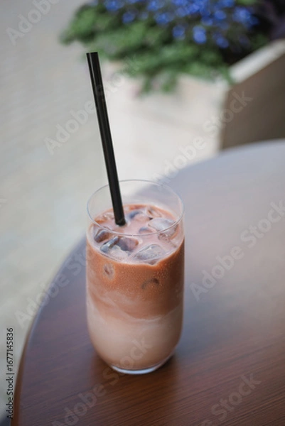 Fototapeta Close-up of an iced cacao drink on a table at a street cafe in summer.