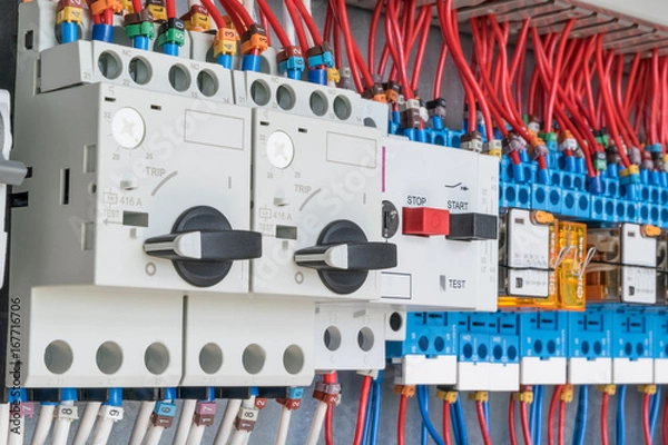 Fototapeta n the electrical control panel are circuit breakers protecting the motor and relay. Circuit breakers with rotary handles and push-button and arranged in a row. Wires with ferrules number coded.