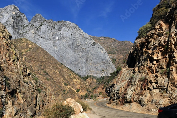 Obraz A mountain road in California, USA, going into the mountains. There is a bright blue sky in the background