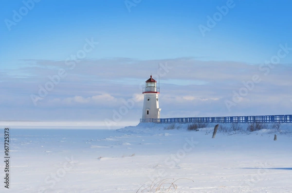 Fototapeta Lighthouse in a calm and desolate winter landscape.