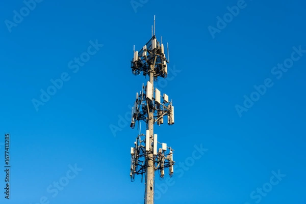 Fototapeta Cell phone tower. Wireless communication. Mobile service. Modern telecommunications infrastructure. Antenna technology of cellular base station. Cell site tower. Broadcasting tower station