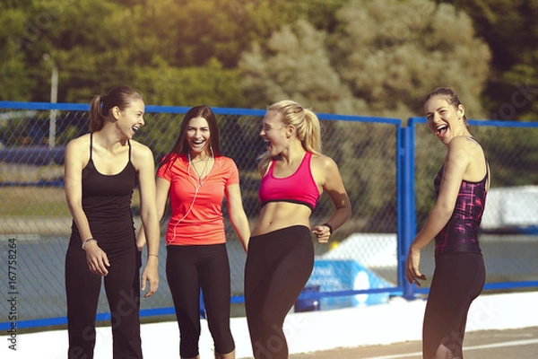 Fototapeta Beautiful sports girls are laughing after sports training. Healthy young women lead a happy and healthy lifestyle.