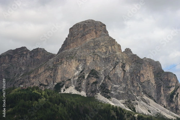 Fototapeta Trentino, Italy - July 29, 2025: Panoramic view of the majestic Piz Boe and the surrounding Dolomite peaks, with lush green valleys and scattered snow, under a clear blue sky. beautiful view to Lake b