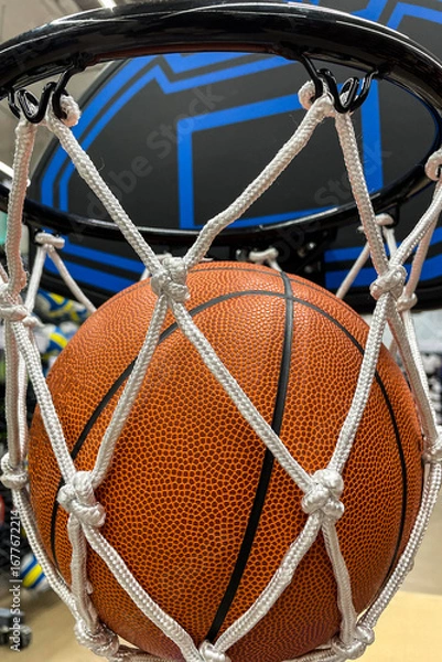 Fototapeta A closeup of a basketball falling through the net to score points