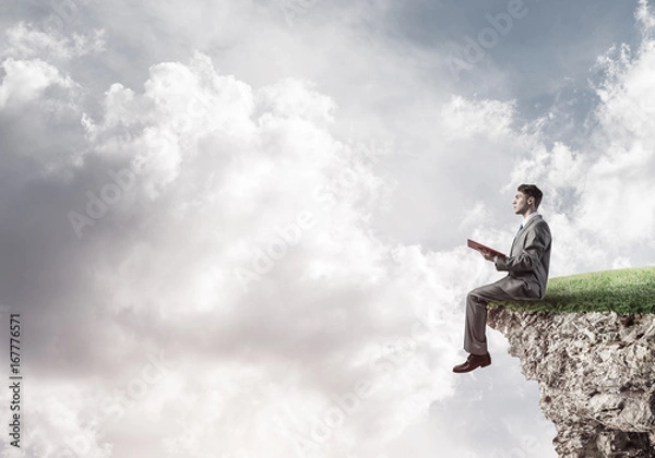 Fototapeta Student guy in suit with book in hands preparing for exam