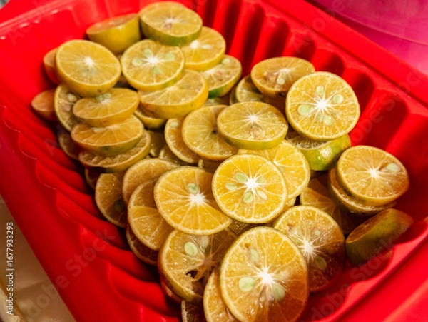 Fototapeta pile of Sliced Oranges in a Red Tray ready to serve
