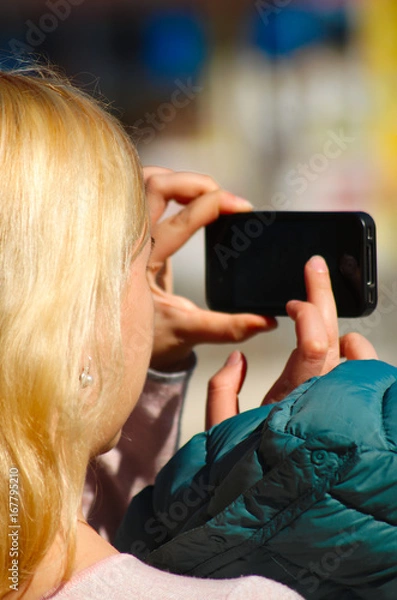 Obraz Young woman with hair blond taking a photo.