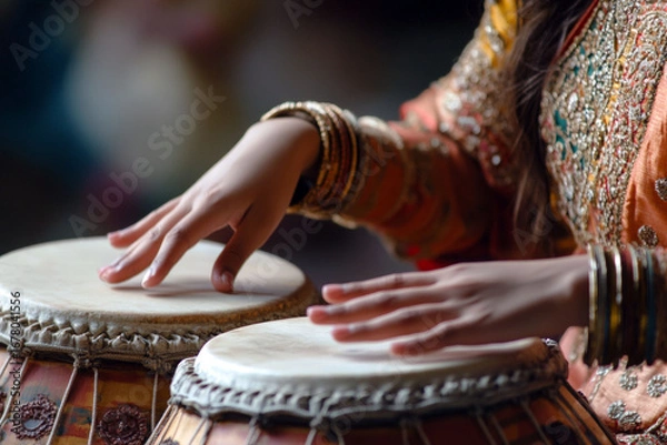 Fototapeta Close up of a woman's hands playing a traditional ethnic drum. Folk instrument performance promoting rhythmic music culture.