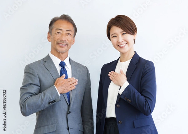 Obraz 胸に手を当てるカメラ目線のビジネスマン男女