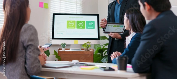 Fototapeta Business meeting sustainability presentation with colleagues office showing ESG dashboard and green metrics monitor and tablet, collaborative team discussing environmental performance and data