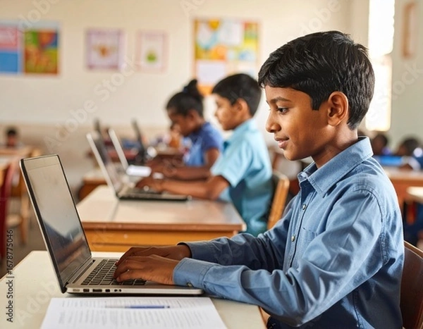 Fototapeta Asian boy typing on a laptop in a modest classroom