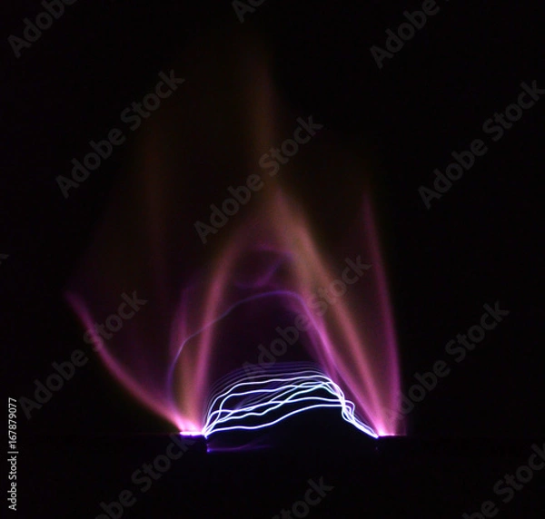 Fototapeta Electric arc between two electrodes seen on a black background.