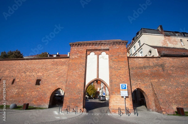 Fototapeta Widok od strony Wisły na zabytkową bramę na bulwarze w Toruniu, Polska. View of the historic gate on the boulevard in Torun, Poland	
