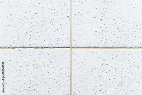 Fototapeta White tiled wall with wet water droplets in a bathroom surface background. About cleaning old dirty grout and home maintenance.