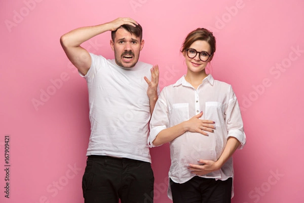 Obraz The funny surprised handsome man and his beautiful pregnant wife's tummy