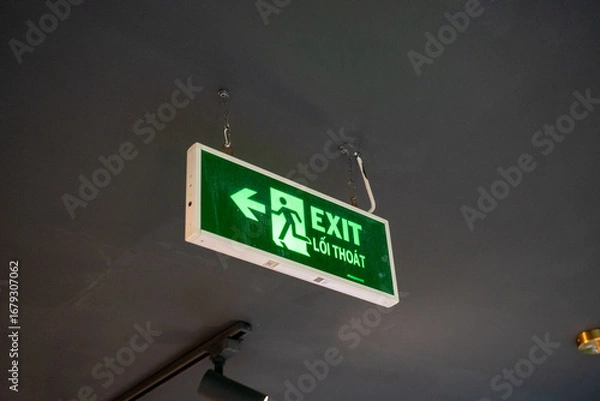 Fototapeta Green exit sign with directional arrow for emergency exits.
