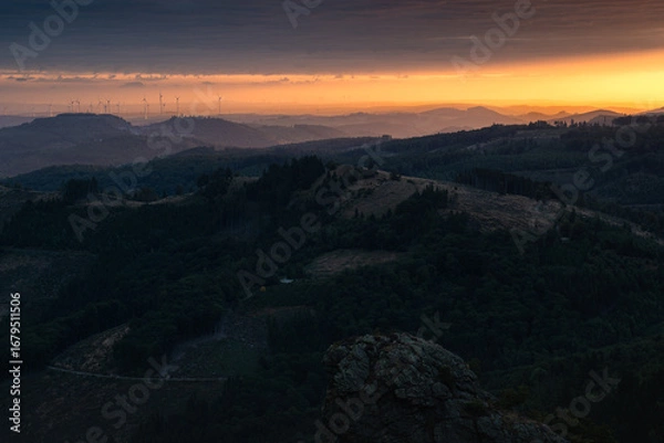 Fototapeta The beautiful landscape of the Sauerland region in Germany, seen from Bruchhausen Steine. Hills dotted with wind turbines, illuminated by the rising sun.