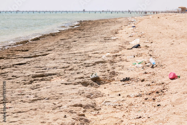 Fototapeta Coastal pollution, plastic bottles, bags of garbage on the seashore. Problems of pollution of the planet, nature and waste recycling.