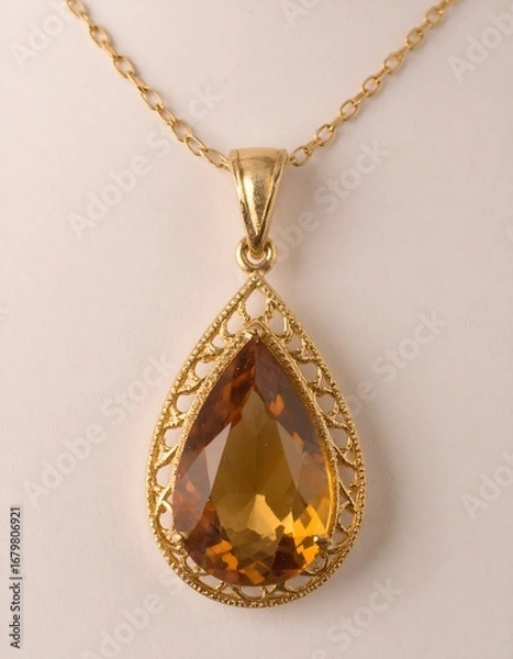 Fototapeta A teardrop-shaped gemstone, set in delicate gold filigree, hangs from a fine chain.