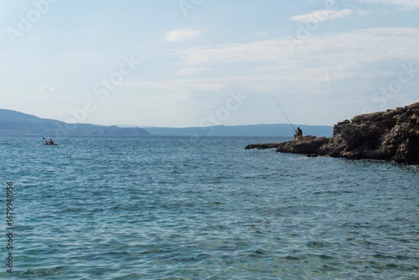 Fototapeta Man Fishing on a Cliff in the Croatian Sea
