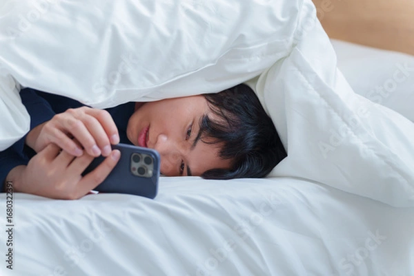 Obraz ベッドでスマホを使う男性