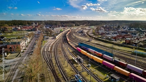 Fototapeta Railroad, train tracks and trains aerial drone view from above, railway station in the Netherlands, transportation, logistics and public transport infrastructure concept
