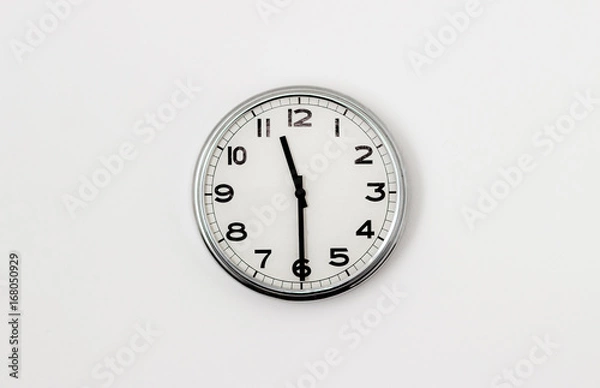 Fototapeta White Clock hanging on a white wall showing time 11:30