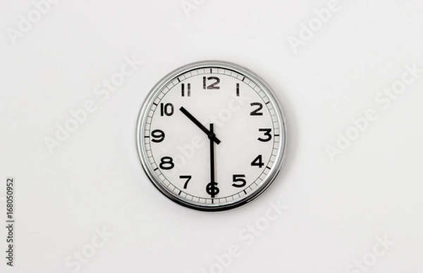 Fototapeta White Clock hanging on a white wall showing time 10:30