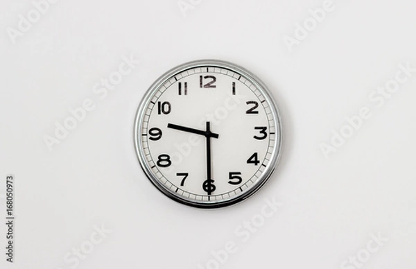Fototapeta White Clock hanging on a white wall showing time 9:30